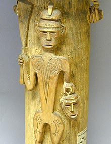 carved figure of a warrior carrying a head